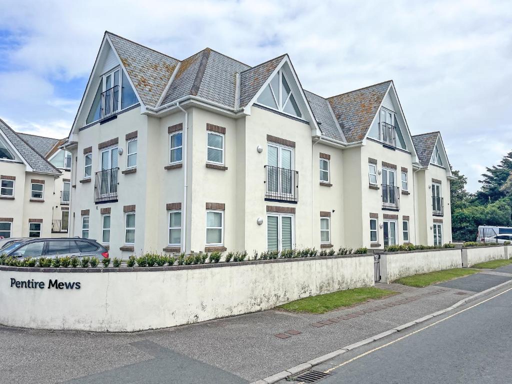 a large white building with a fence in front of it at 6 Pentire Mews in Newquay