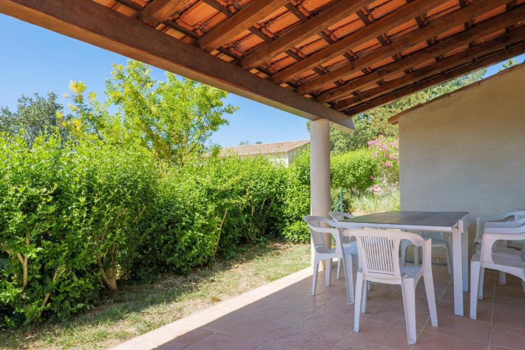 a patio with a table and chairs under a pergola at Le Peuplier - La Fontinelle in Bessas