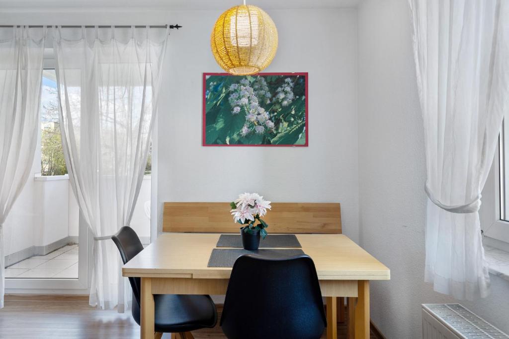 a dining room table with a vase of flowers on it at Apartment 44 in Bad Dürrheim