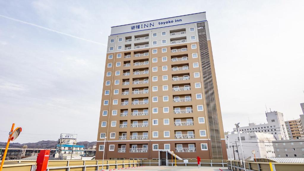 a tall building with a sign on top of it at Toyoko Inn Kitakami-eki Nishi-guchi in Kitakami