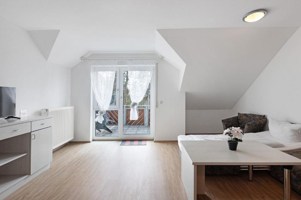 a white living room with a couch and a table at Apartment 36 in Bad Dürrheim