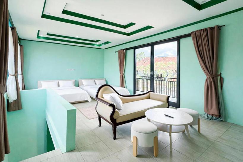 a living room with a couch and a table at Cozzy Malakai Guesthouse in Palayangan