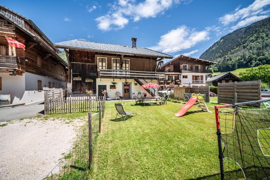 a yard with a playground in front of a house at Maison De La Coutettaz in Morzine