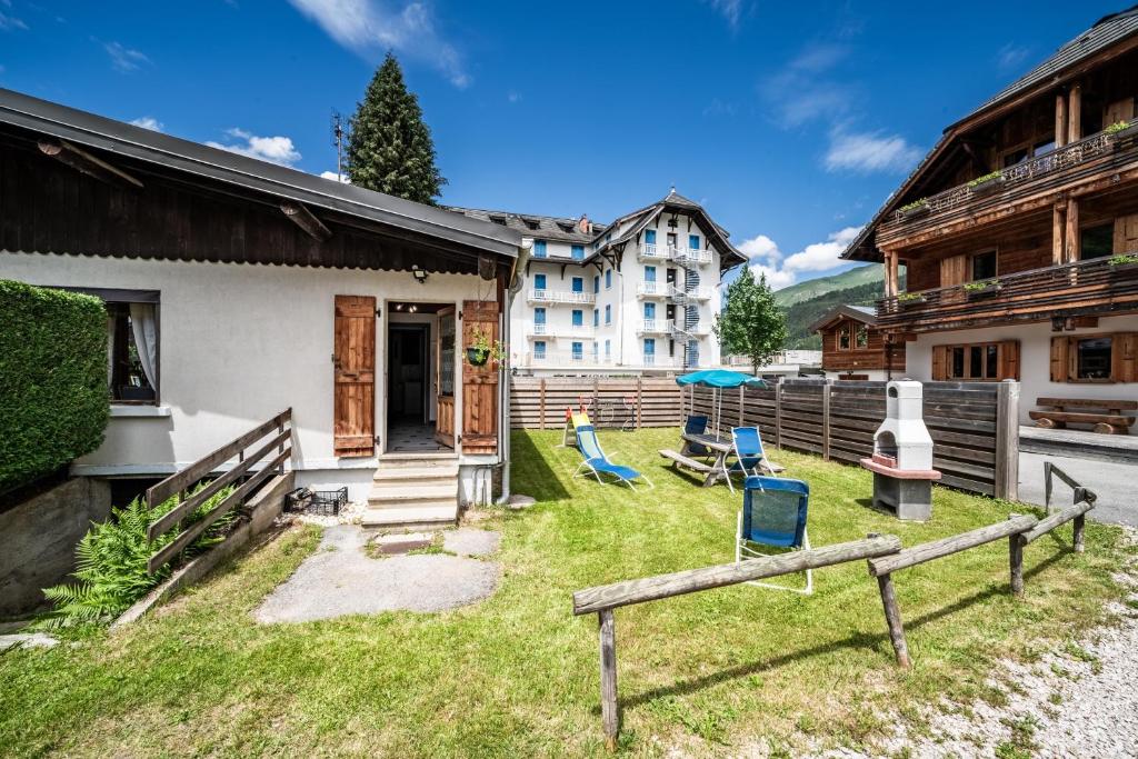 a house with a yard with chairs in front of it at Le petit Chalet in Morzine