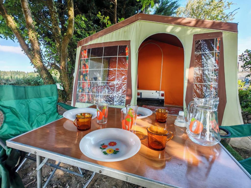 a table with plates of food on top of a tent at une nuit insolite en 1980 in Crédin