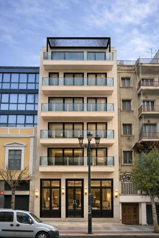 an apartment building with a car parked in front of it at Ormos Piraeus in Piraeus