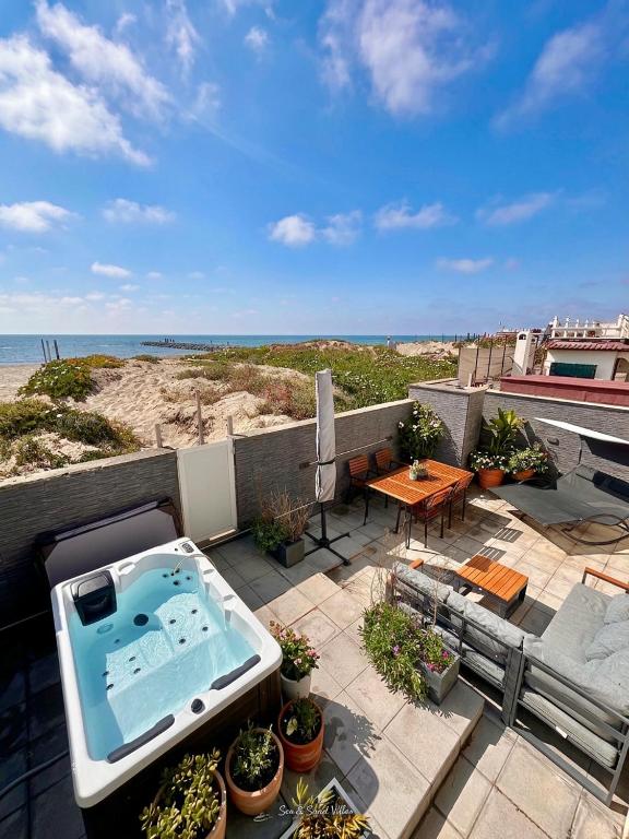 a patio with a jacuzzi tub on top of a balcony at Fiorucci Apartments - Marco's House in Focene