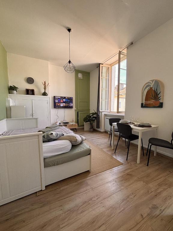 a bedroom with a bed and a table and chairs at Le Cocon Bressan hyper centre & lumineux in Bourg-en-Bresse