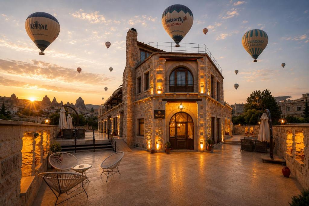 a group of hot air balloons flying over a building at Premium Cappadocia in Göreme