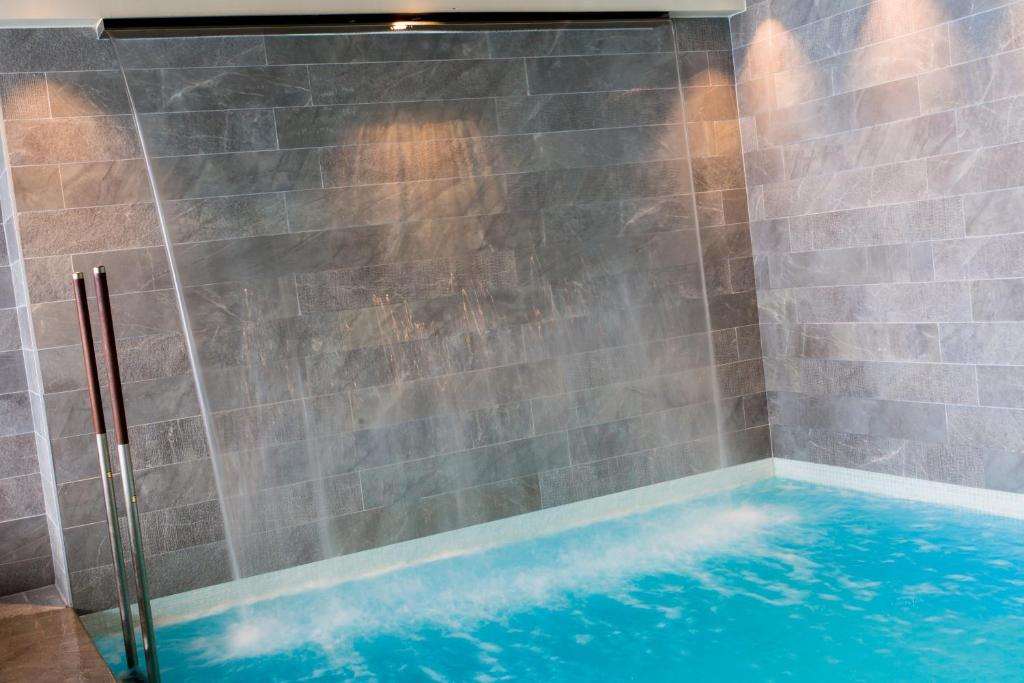 a bathroom with a shower with blue water at Hôtel Taj-I Mah by Les Etincelles in Arc 2000