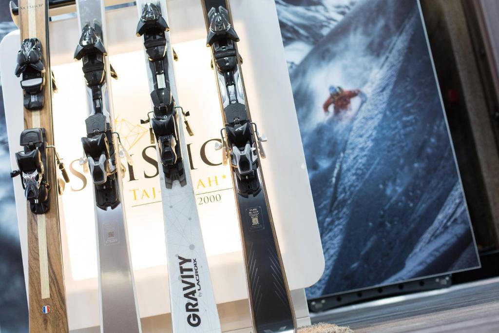 a group of skis on a rack next to a screen at Hôtel Taj-I Mah by Les Etincelles in Arc 2000