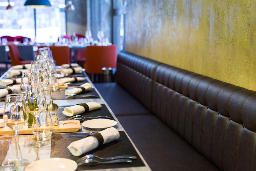 a row of tables in a restaurant with wine glasses at Hôtel Taj-I Mah by Les Etincelles in Arc 2000
