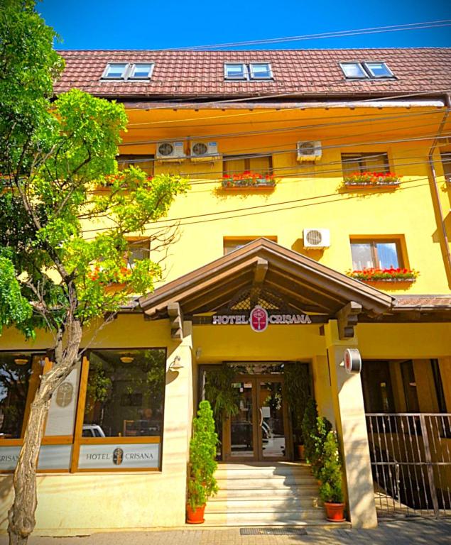 a yellow building with a entrance to a building at Hotel Crisana Arad in Arad