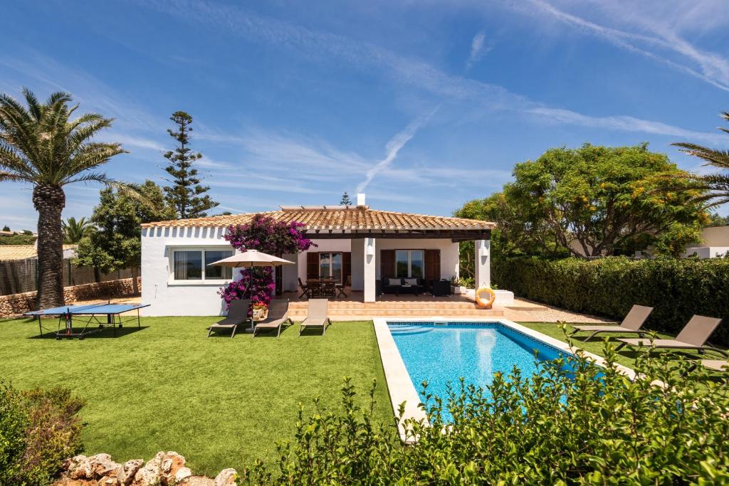 a backyard with a pool and a house at Villa Ribes by Escape Home in Binibeca