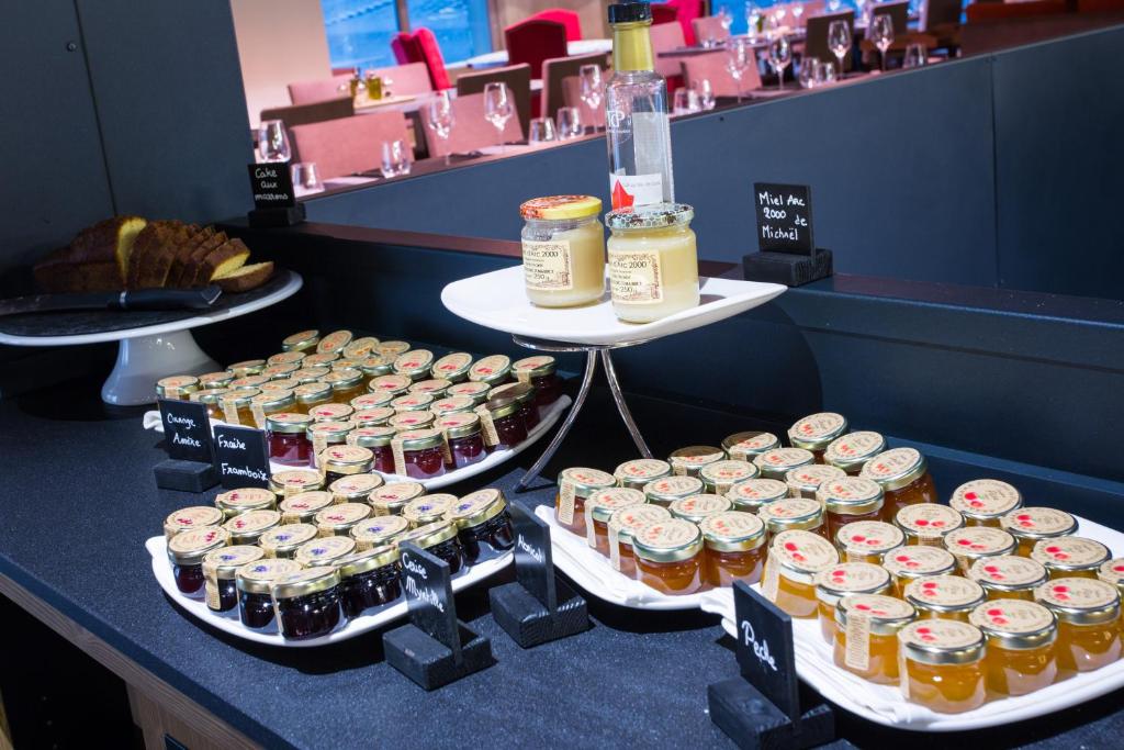 a table topped with lots of jars of jam and honey at Hôtel Taj-I Mah by Les Etincelles in Arc 2000