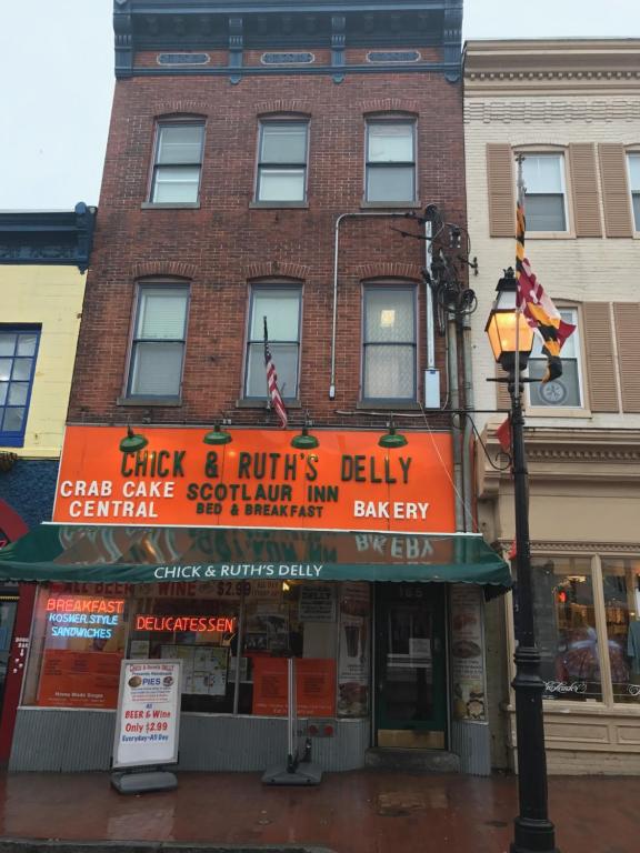 un edificio di mattoni con un cartello arancione di Inn on Main Annapolis ad Annapolis