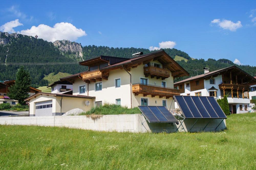 a house with solar panels on it in a field at Ferienwohnungen Perterer in Fieberbrunn