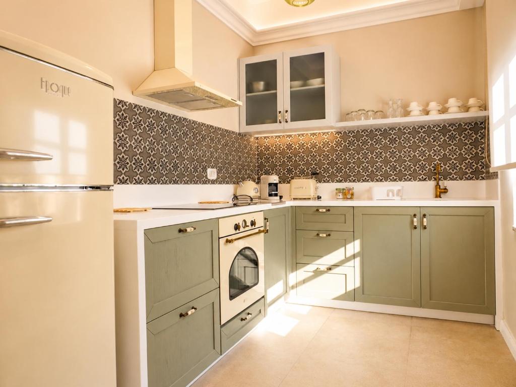 a kitchen with green cabinets and a refrigerator at Athena Collection in Kefalos