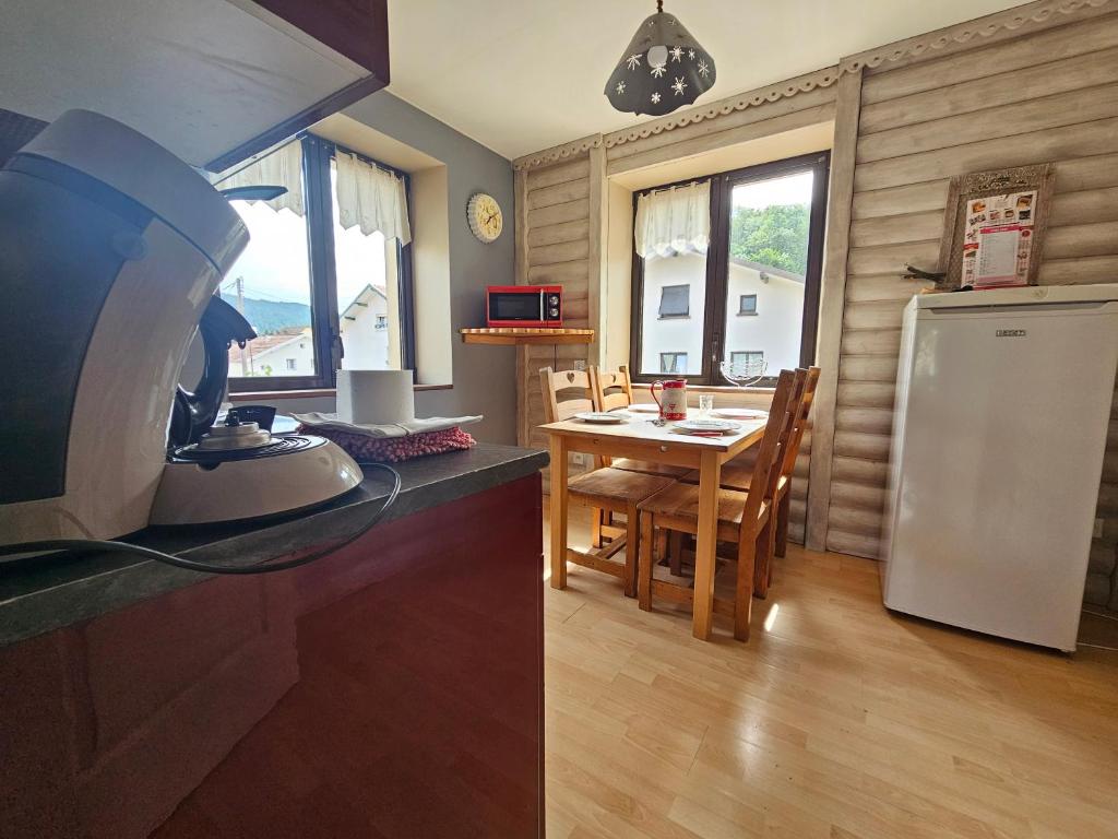 a kitchen with a white refrigerator and a table at Superbe appartement 2 a 6 pers. hyper cocooning in Gérardmer
