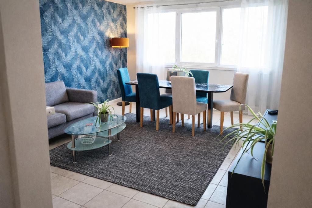 a living room with a couch and a table and chairs at Chambre 3 privée lit double Béthune centre in Béthune