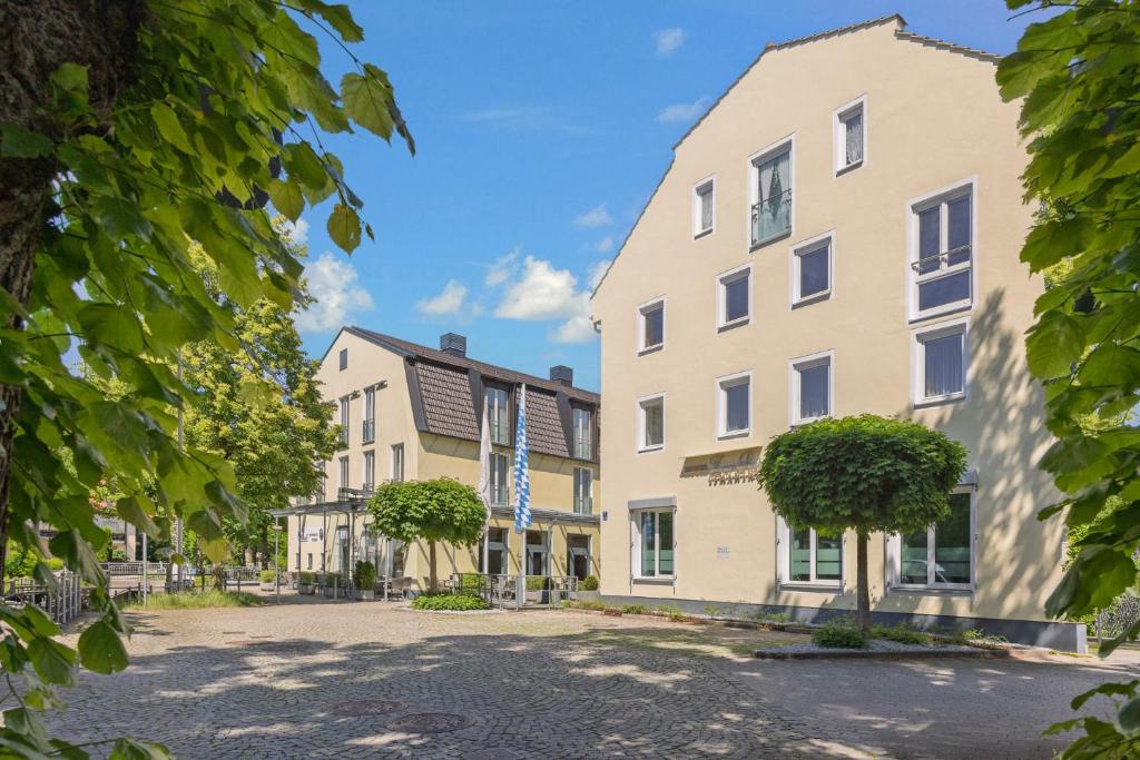 a row of buildings in a street with trees at Hotel Zur Post in Ismaning