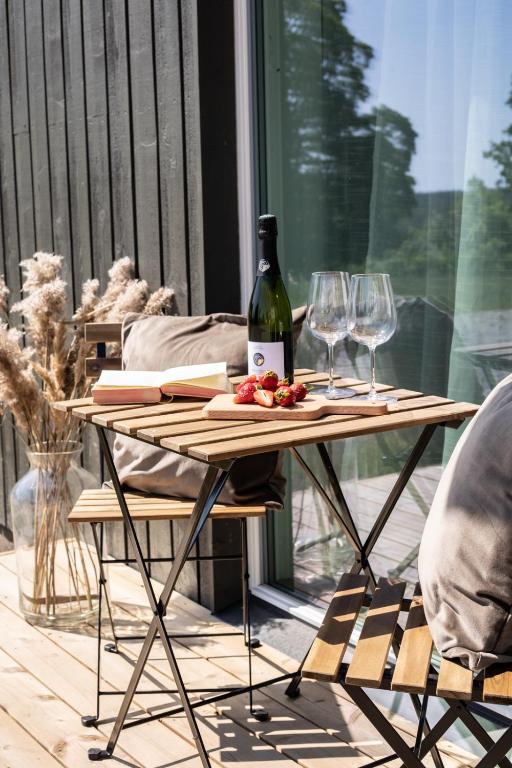 a table with a bottle of wine and wine glasses at Järvevaatega studio apartment in Viljandi
