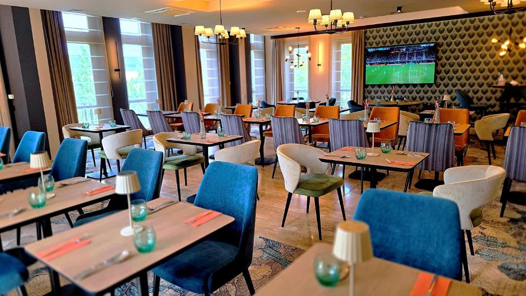 ein Esszimmer mit Tischen und Stühlen und einem Fernseher in der Unterkunft Hotel Vécsecity in Hernádvécse