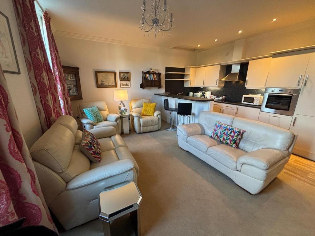 a living room with two couches and a kitchen at Apartment No.1 in Lincoln