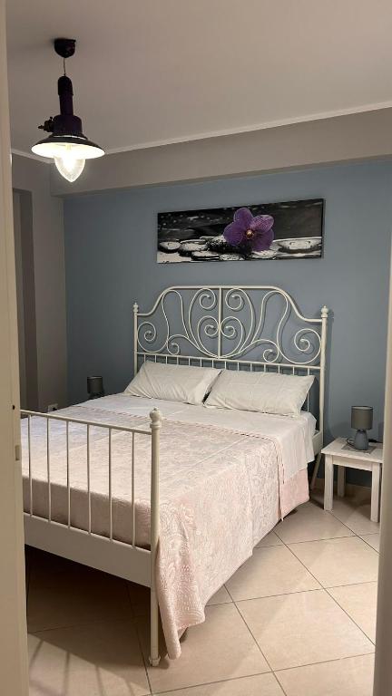 a bedroom with a bed with a purple flower on the wall at La camera a Lido Burrone in Favignana