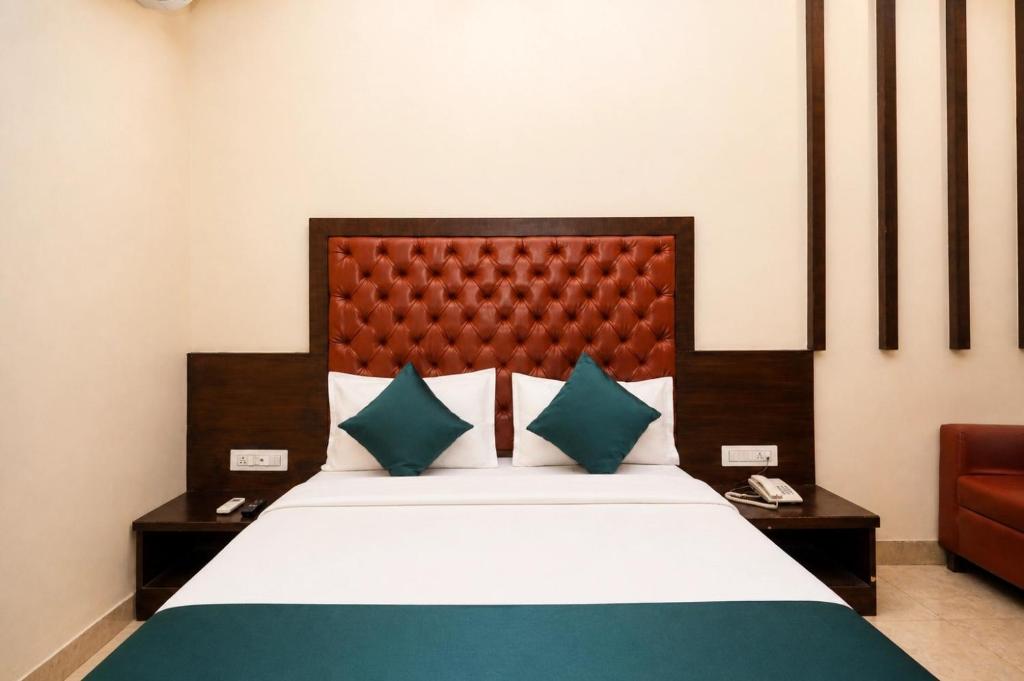 a bedroom with a large bed with blue and green pillows at Hotel BKC Suite in Mumbai