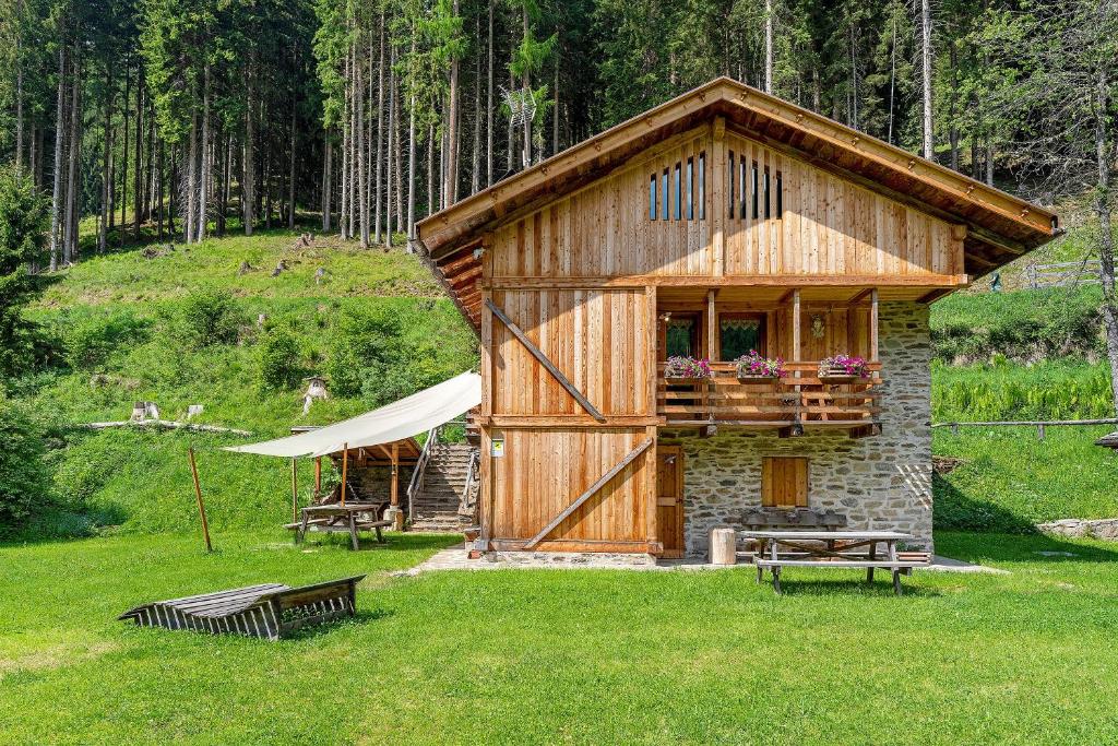 a small building in the grass with a tent and benches at Bnb Erba Maga in Rabbi