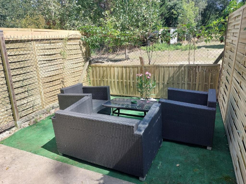 a patio with two wicker chairs and a table at Pavilion - T3 Duplex, avec Terrasse et Parking in Montagnat