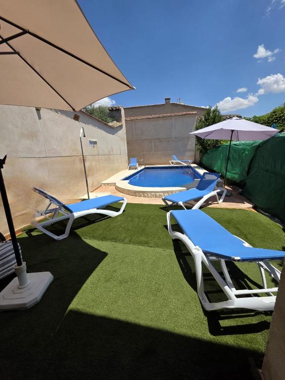 a group of chairs and an umbrella and a pool at Casa Rural Hidalgo II in Alcolea de Calatrava