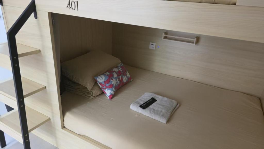 a small room with a bed and a book at silom lestay纯女民宿 in Yan Nawa