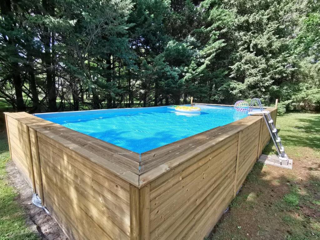 a swimming pool with a wooden fence around it at Chambres - La Chenevelle in Chitenay