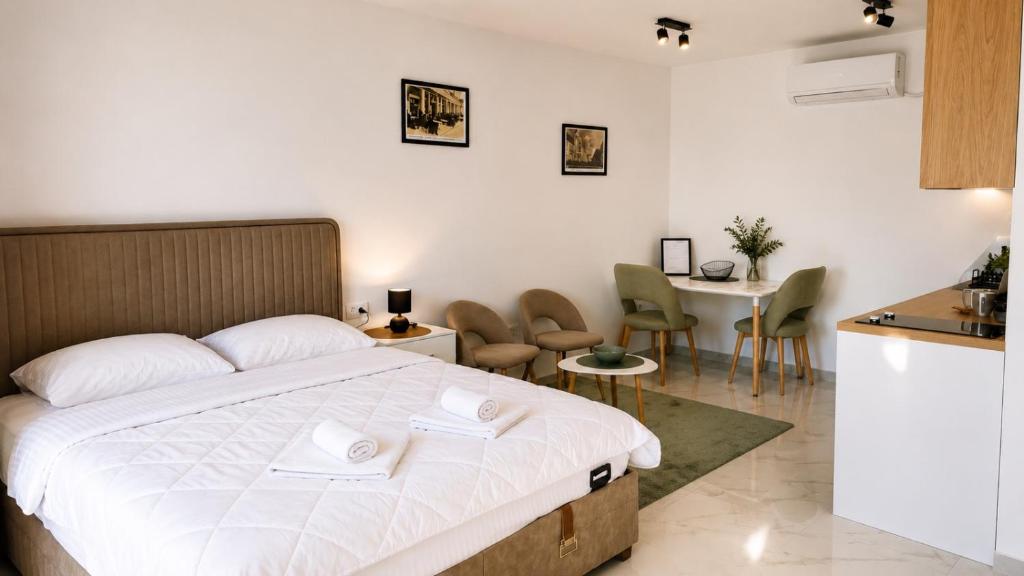 a bedroom with a bed and a table and chairs at The River Studio Beli in Podgorica