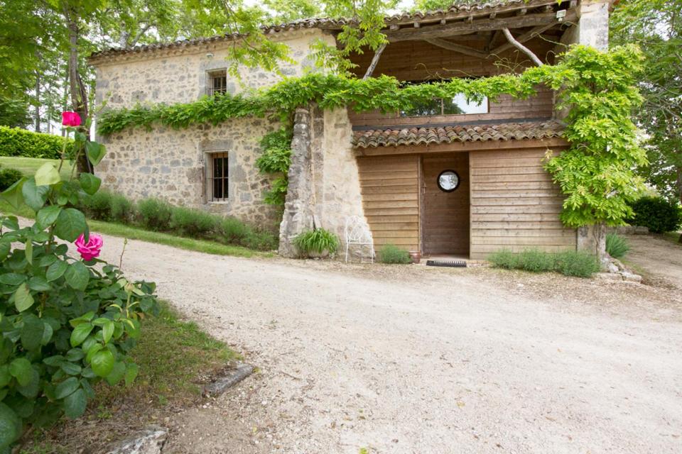 an old house with a tree in front of a dirt road at GITE FOUR A PAIN 4 pers in Bon-Encontre