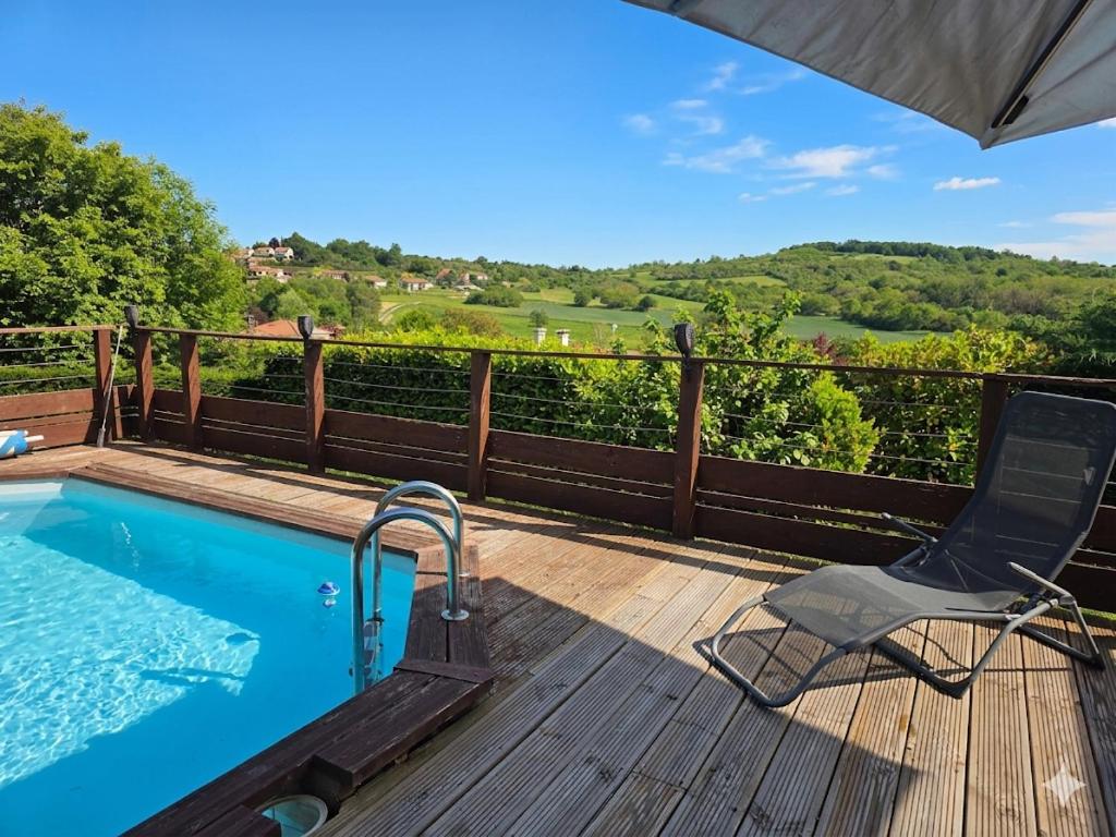 a deck with a chair and a swimming pool at Châtel-guyon : Appart cosy avec place de parking et piscine près des thermes in Châtel-Guyon