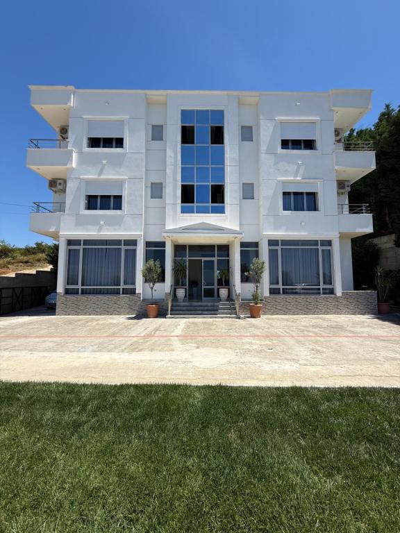 a white apartment building with a large yard at MEGA Apartments in Fushë-Draç