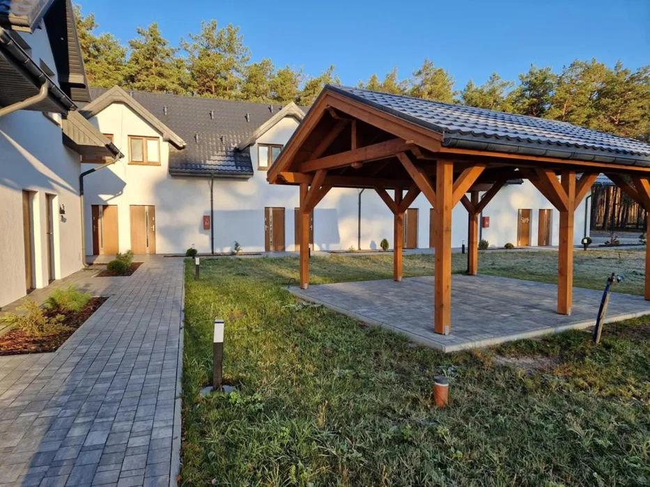 a wooden pavilion in a yard next to a house at Apartament Konecka 2J in Sielpia Wielka