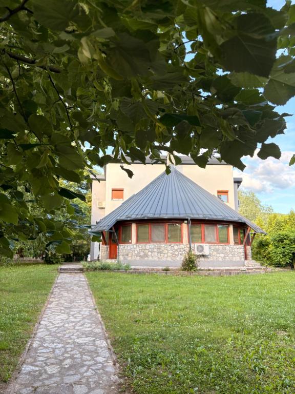 a building with a black roof in a field at Una Serenity Villa in Bare