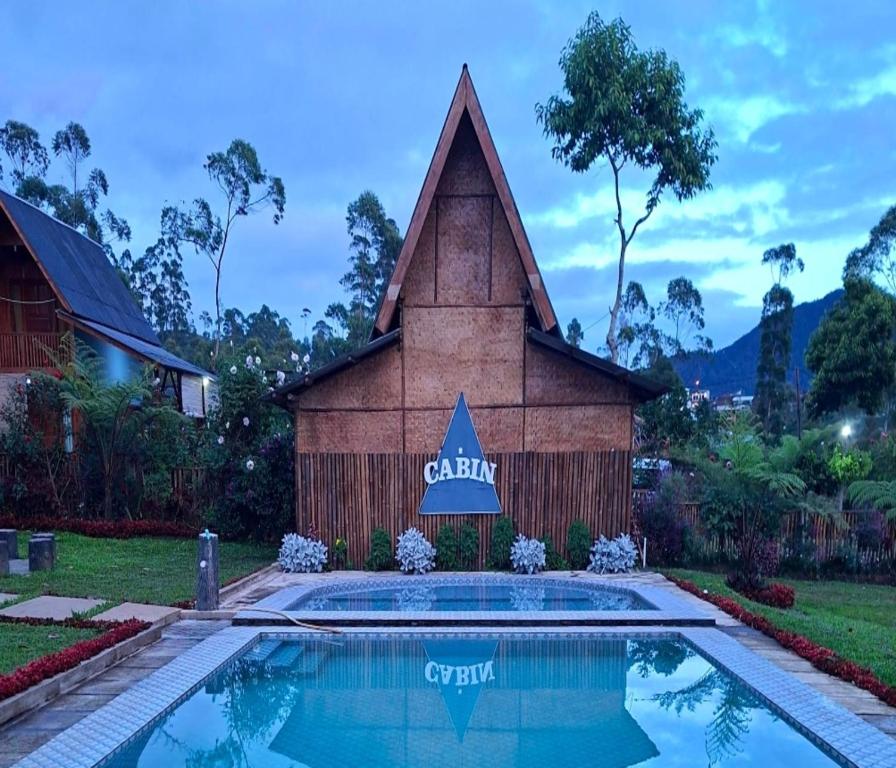 a church with a swimming pool in front of it at Cozzy Artana Cabin in Palayangan