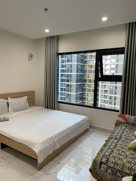 a bedroom with a large bed and a large window at Anna Vinhomes Grand Park in Ho Chi Minh City