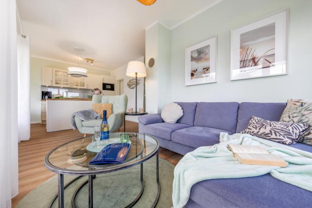 a living room with a purple couch and a glass table at FeWo Lieblingsplatz in Zingst