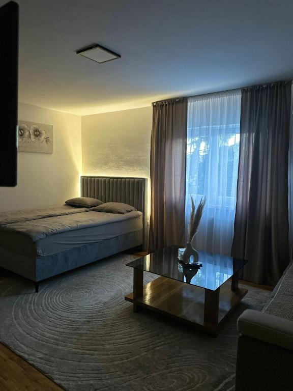 a bedroom with two beds and a coffee table at Apartman Bugojno in Bugojno