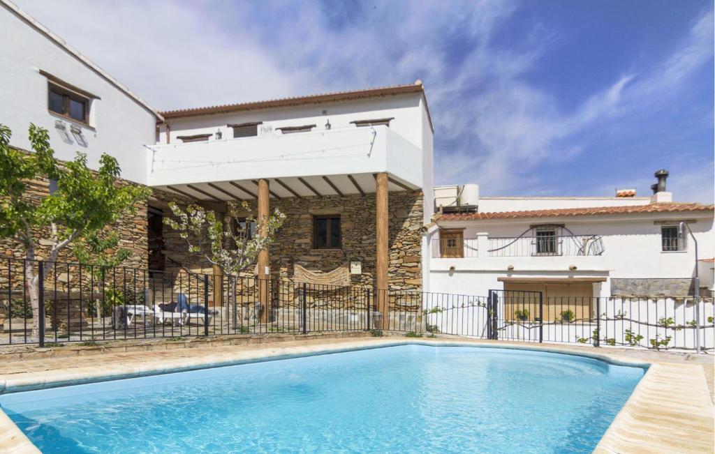 a swimming pool in front of a house at La Curiosa in Laroya