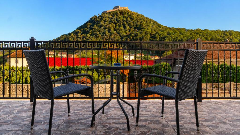 two chairs and a table in front of a fence at Casa de oaspeti Minerva in Deva