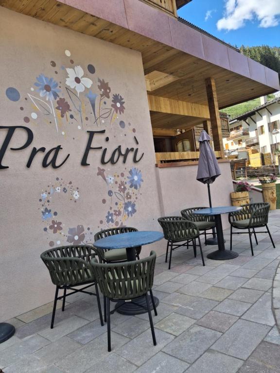 a patio with tables and chairs in front of a pizza hut at Garnì Prà Fiorì in Campitello di Fassa