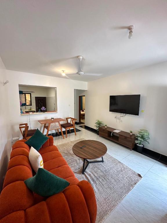 a living room with a couch and a table at Diani Beach Modern Apartment in Diani Beach