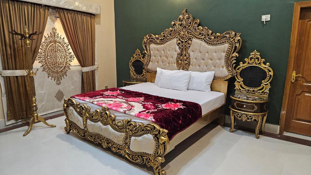 a bedroom with an ornate bed with a gold frame at Hotel Destination in Sukkur